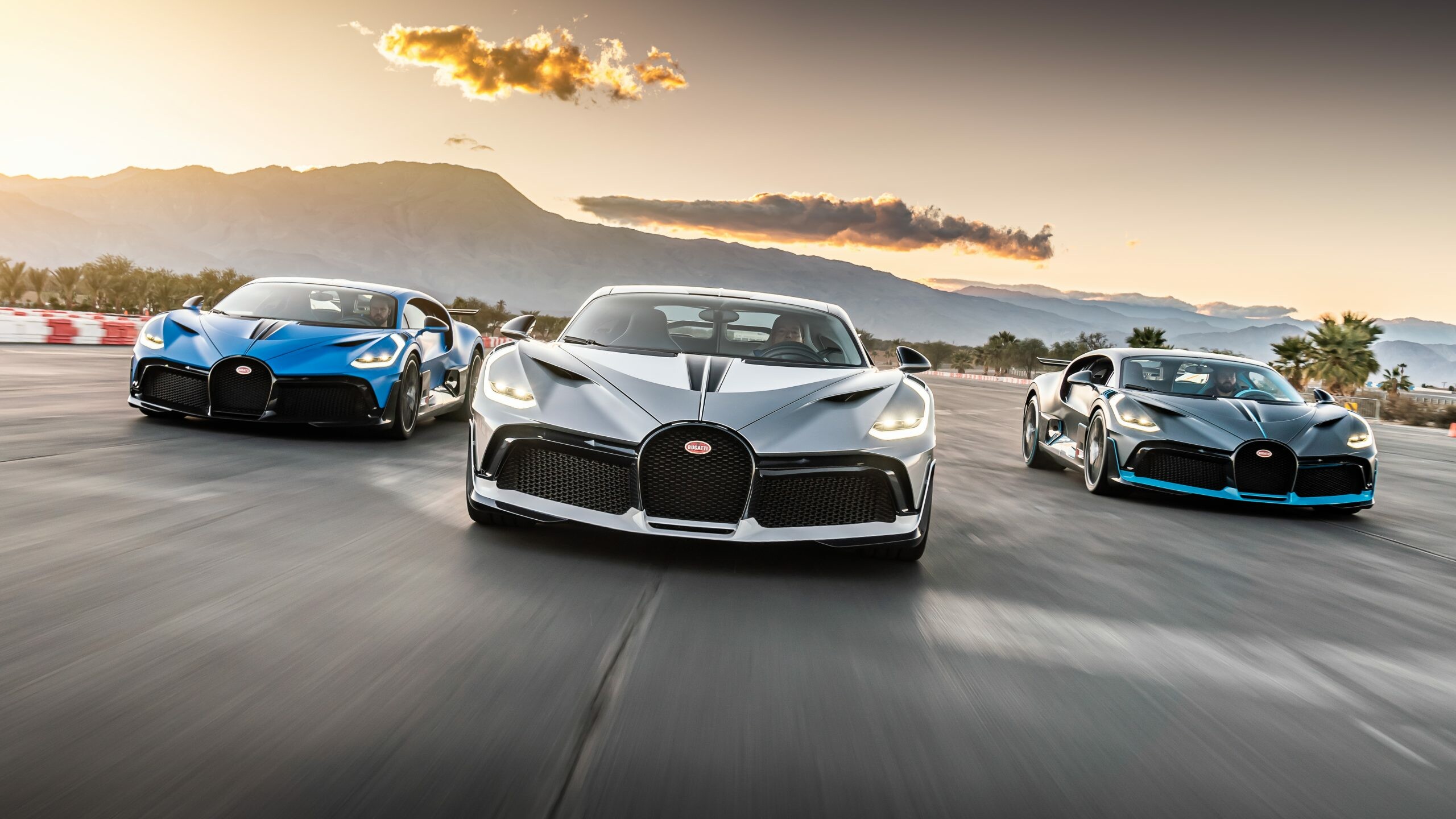Bugatti Divo, Trio driving formation, Sunset mountain backdrop, Blue white grey liveries Bugatti Divo, Trio driving formation, Sunset mountain backdrop, Blue white grey liveries — 2560×1440 HD wallpaper
