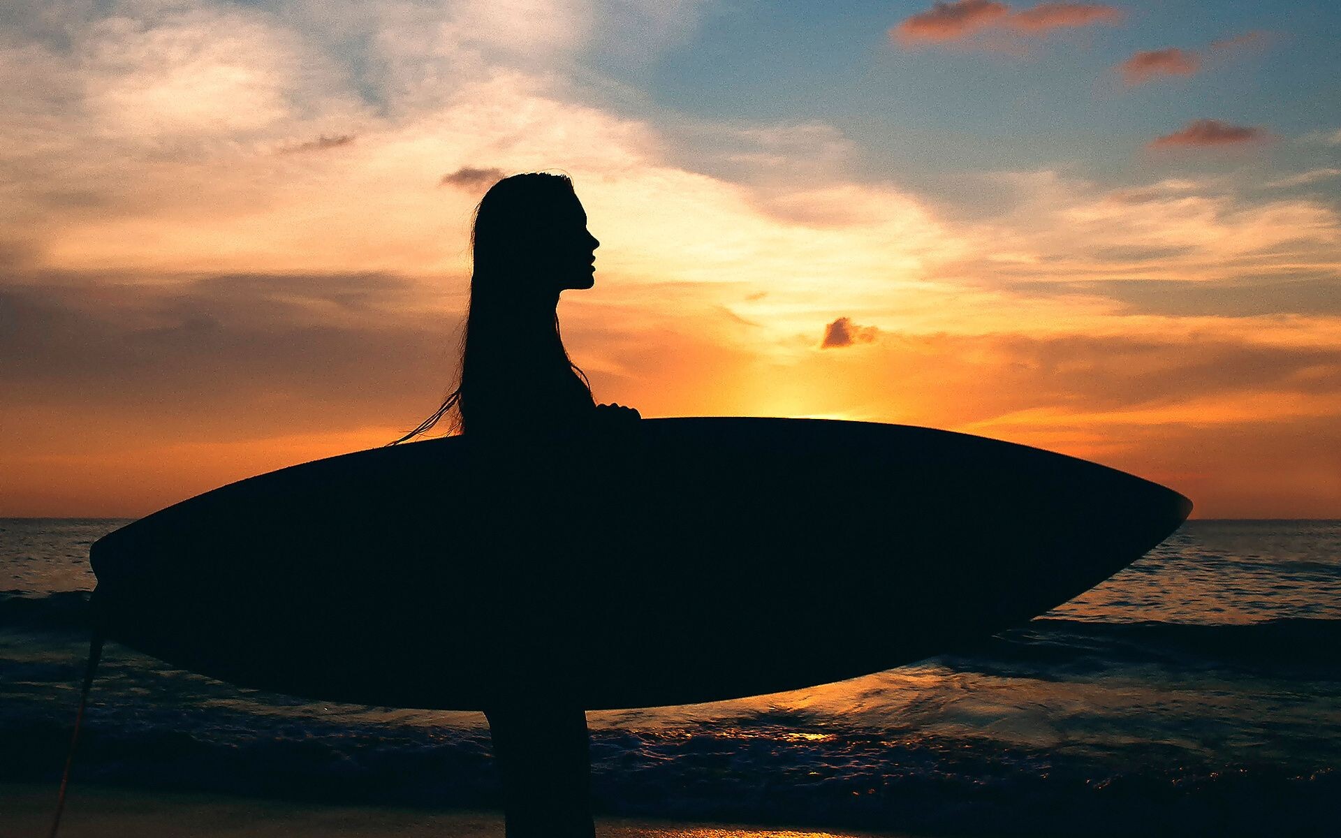 Silhouetted girl holding surfboard, Sunset ocean horizon, Orange cloudy sky Silhouetted girl holding surfboard, Sunset ocean horizon, Orange cloudy sky — 1920×1200 HD wallpaper