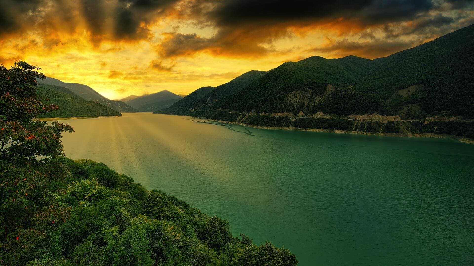 Mountain lake valley, Golden sunrays through clouds, Forested green slopes, Teal green water Mountain lake valley, Golden sunrays through clouds, Forested green slopes, Teal green water — 1920×1080 HD wallpaper