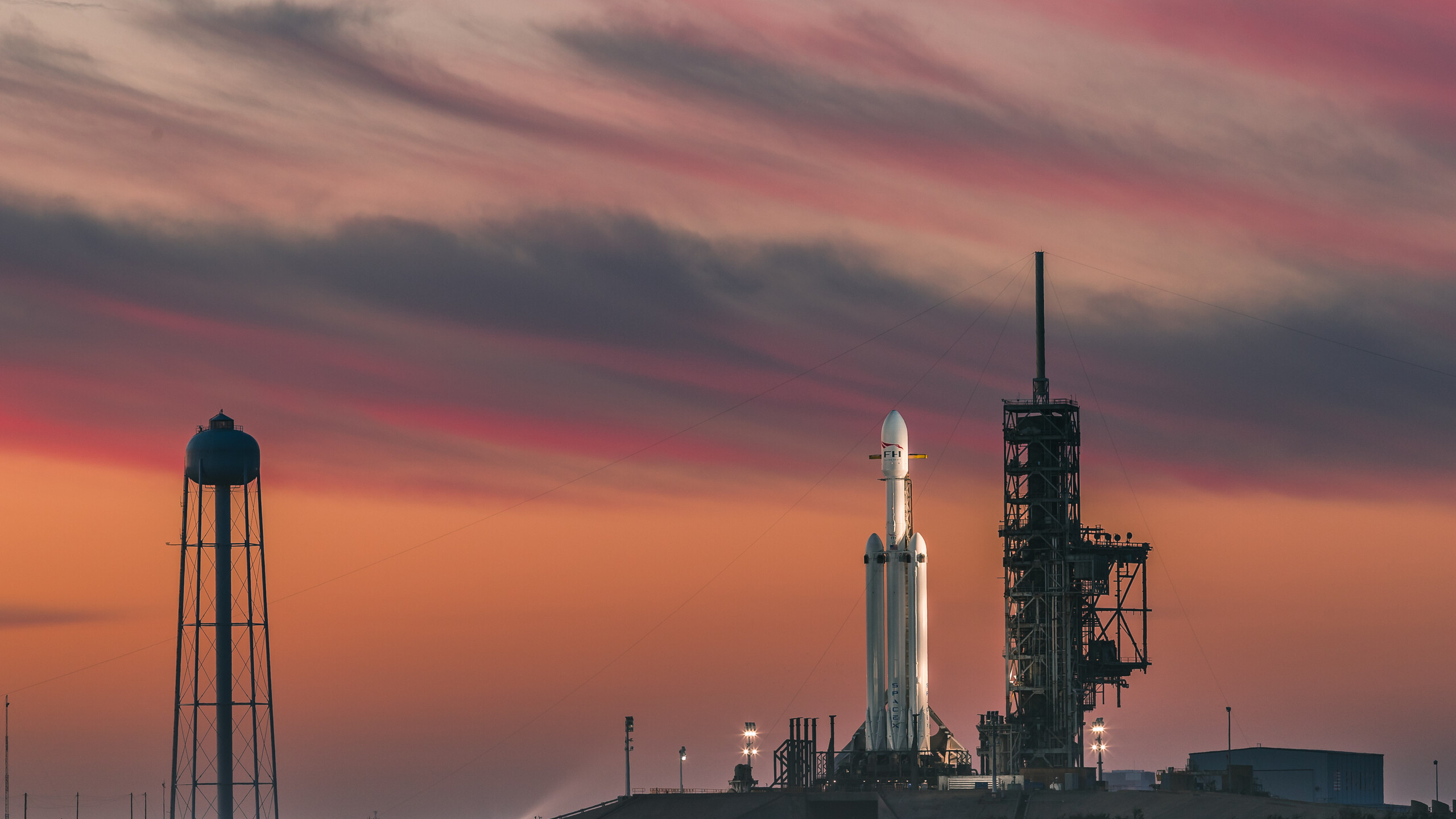 SpaceX Falcon Heavy, Kennedy Space Center launchpad, Sunset water tower silhouette SpaceX Falcon Heavy, Kennedy Space Center launchpad, Sunset water tower silhouette — 2560×1440 HD wallpaper