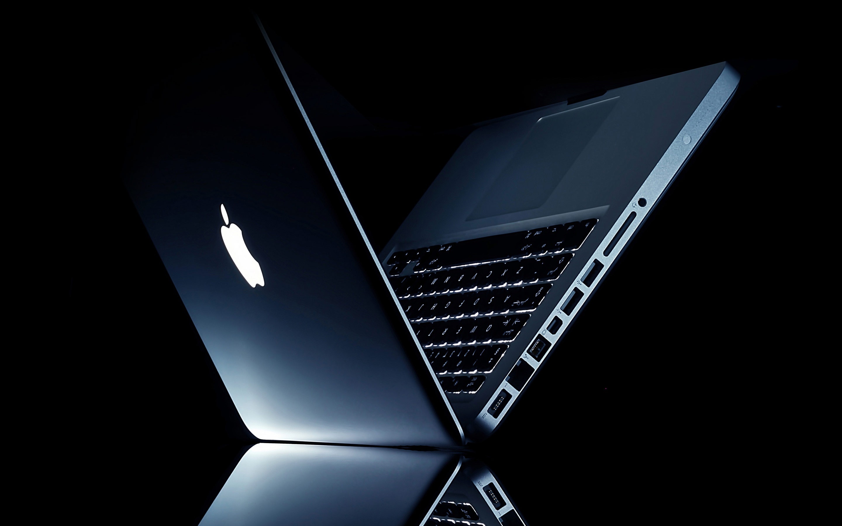 Two MacBook Pros, Glowing Apple logo, Low-key black backdrop Two MacBook Pros, Glowing Apple logo, Low-key black backdrop — 2880×1800 HD wallpaper