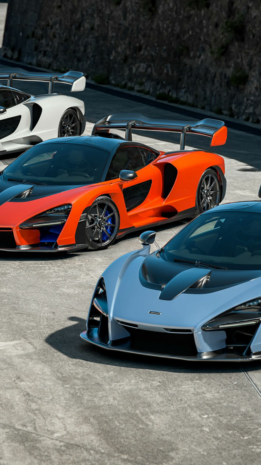 McLaren Senna trio, Orange carbon hypercar, Rock wall backdrop McLaren Senna trio, Orange carbon hypercar, Rock wall backdrop — 1080×1920 HD wallpaper