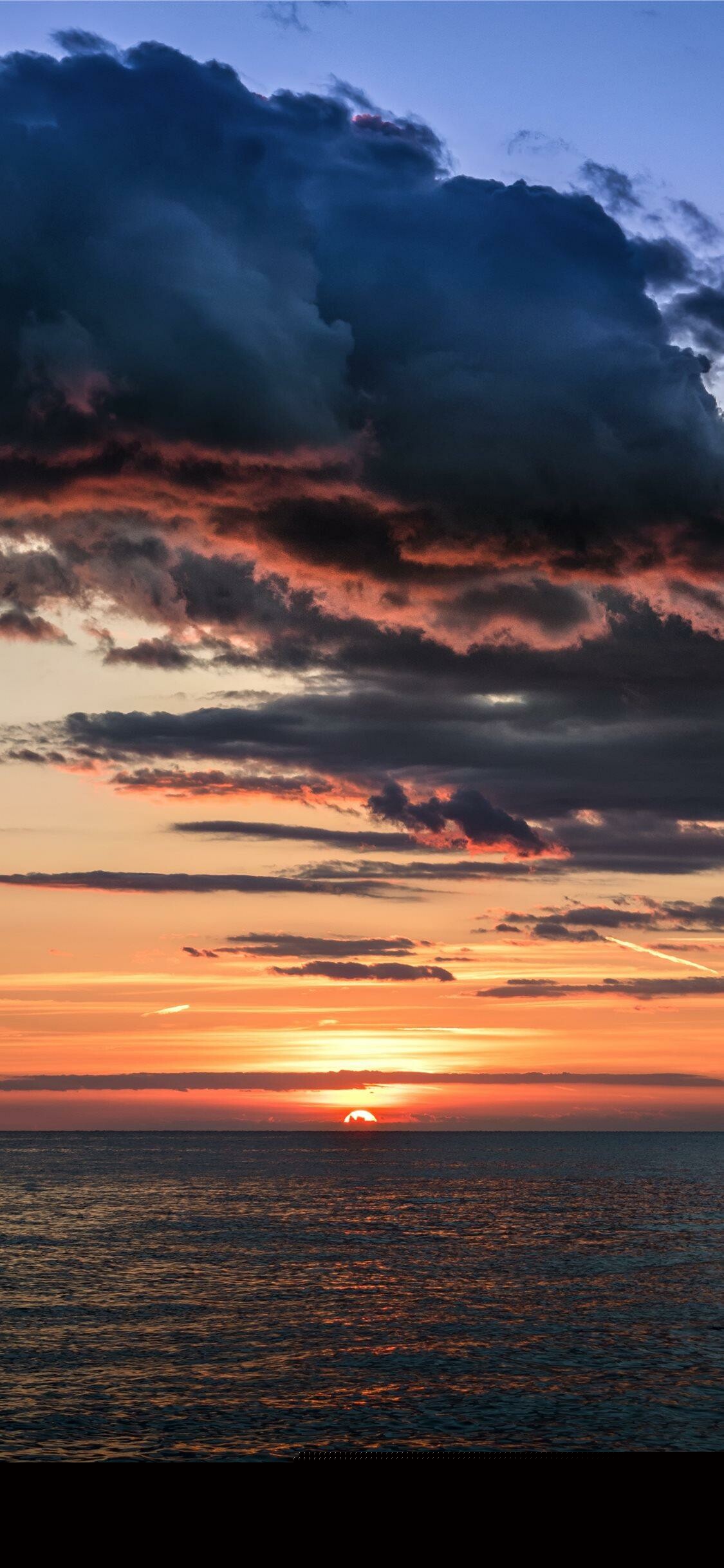 Ocean sunset horizon, Dark storm clouds, Setting sun over sea Ocean sunset horizon, Dark storm clouds, Setting sun over sea — 1125×2436 HD wallpaper