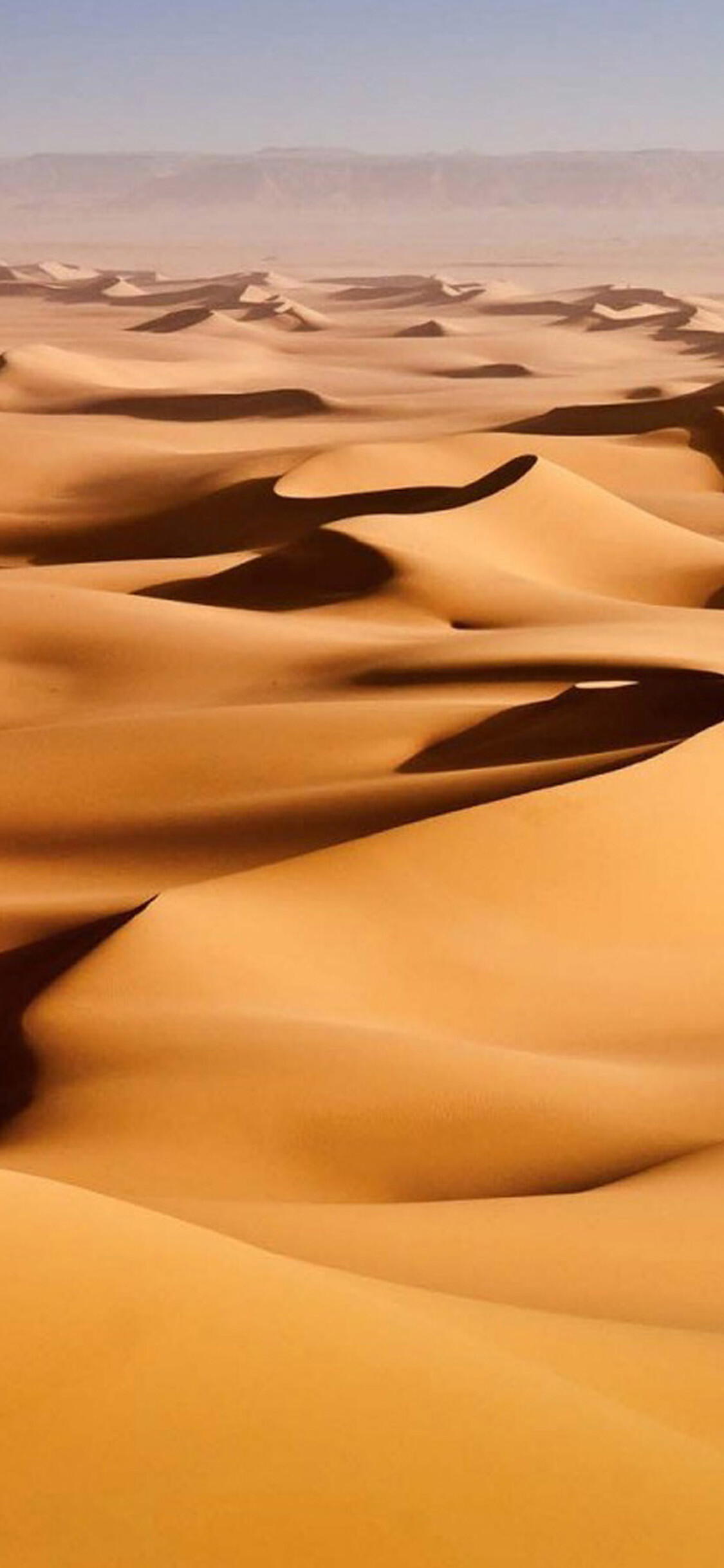Rolling sand dunes, Distant mountain ridge, Hazy desert horizon Rolling sand dunes, Distant mountain ridge, Hazy desert horizon — 1125×2437 HD wallpaper