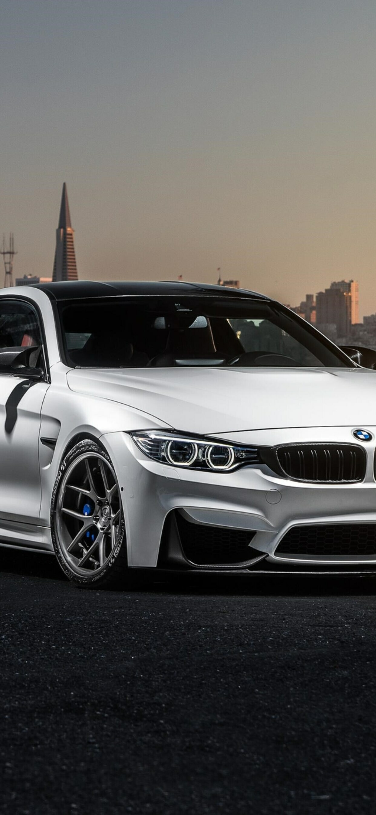 BMW M4 (F82), White paint, San Francisco skyline backdrop, Rooftop at dusk — 1242×2688 mobile wallpaper
