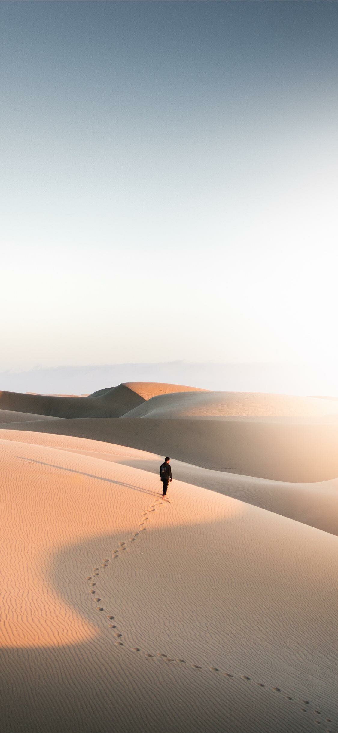 Lone figure walking dunes, Footprints in sand, Golden desert dunes Lone figure walking dunes, Footprints in sand, Golden desert dunes — 1125×2436 HD wallpaper