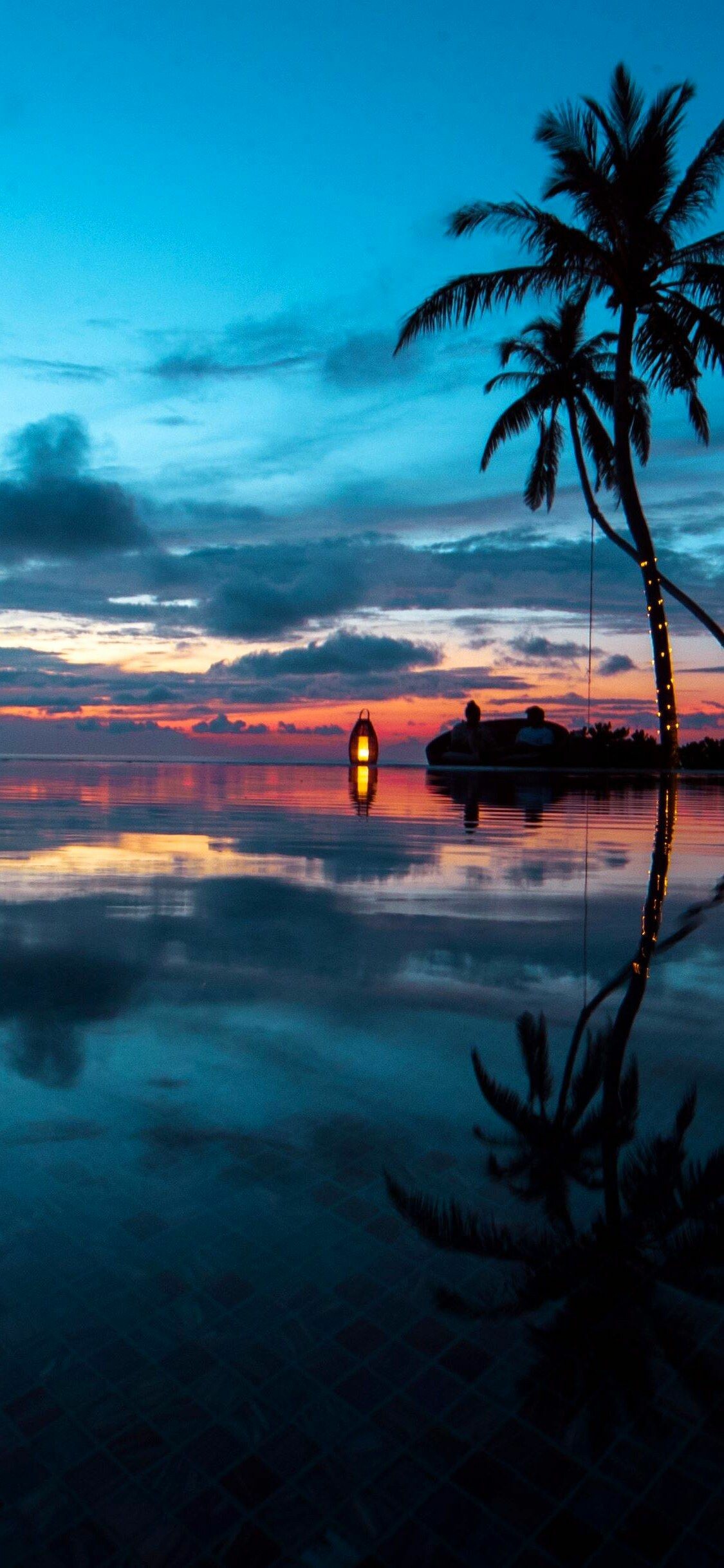 Silhouetted palm tree, Tropical sunset lagoon, Glowing lantern reflection Silhouetted palm tree, Tropical sunset lagoon, Glowing lantern reflection — 1125×2436 HD wallpaper