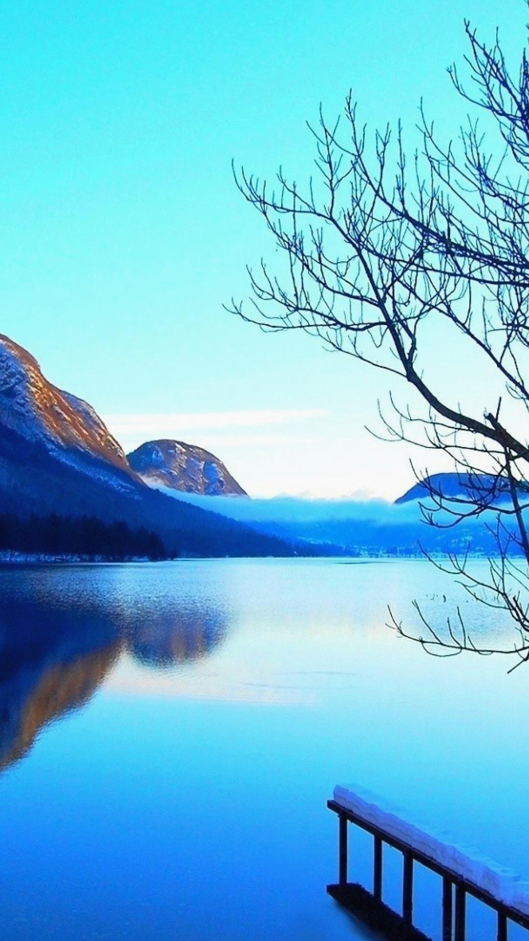 Snow-capped mountain lake, Bare tree branches, Snow-covered wooden dock Snow-capped mountain lake, Bare tree branches, Snow-covered wooden dock — 1080×1920 HD wallpaper
