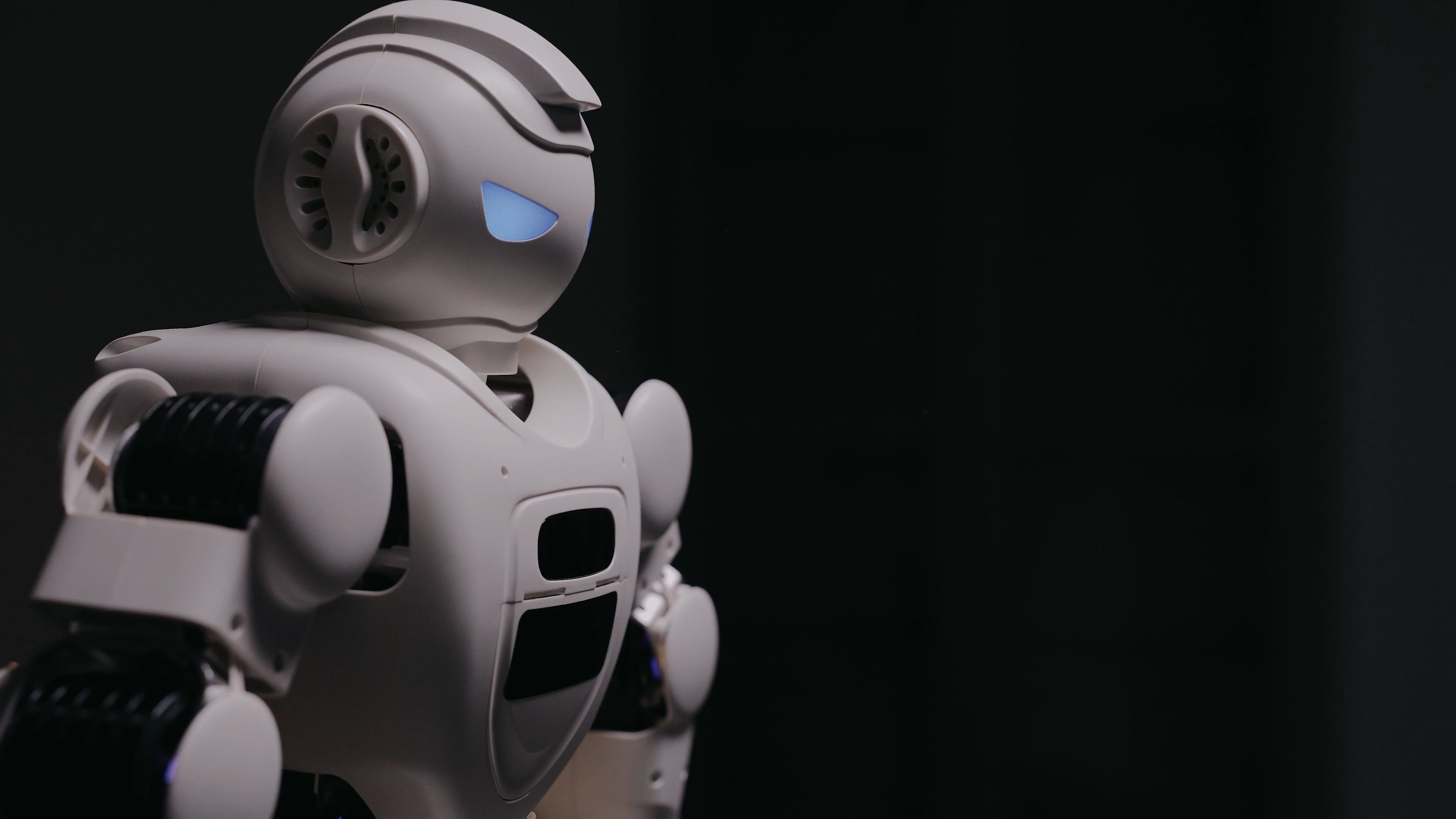 White humanoid robot, Glowing blue eye, Dark studio backdrop White humanoid robot, Glowing blue eye, Dark studio backdrop — 3840×2160 HD wallpaper