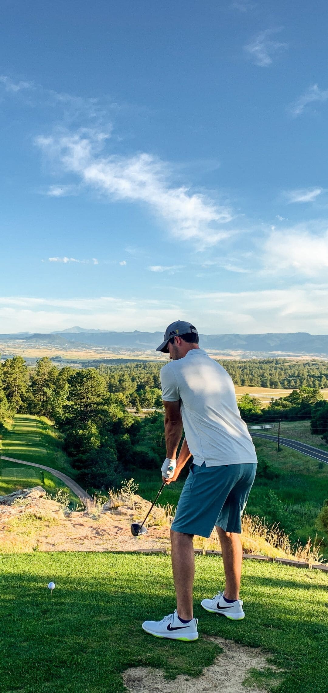 Golfer mid-swing tee, Elevated mountain fairway, Nike sneakers blue shorts Golfer mid-swing tee, Elevated mountain fairway, Nike sneakers blue shorts — 1080×2280 HD wallpaper