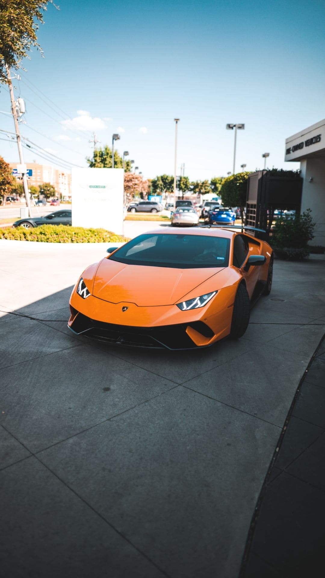Orange Huracan Performante, Dealership parking lot, High-angle front view Orange Huracan Performante, Dealership parking lot, High-angle front view — 1080×1920 HD wallpaper