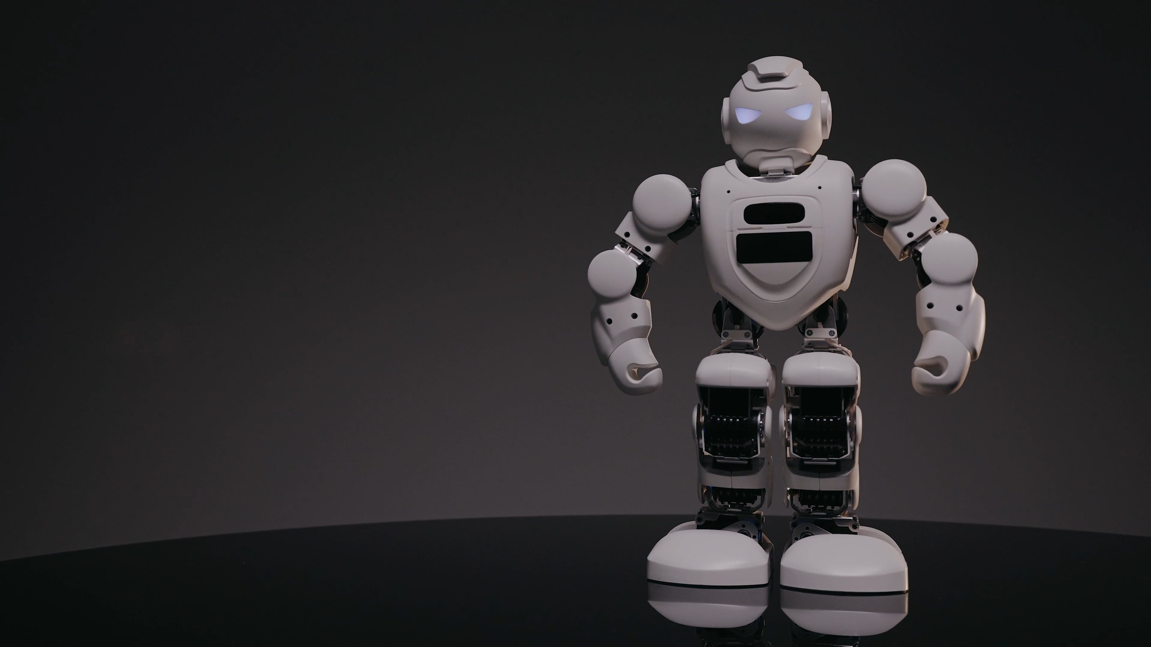 White humanoid robot, Glowing blue eyes, Dark studio backdrop White humanoid robot, Glowing blue eyes, Dark studio backdrop — 3840×2160 HD wallpaper