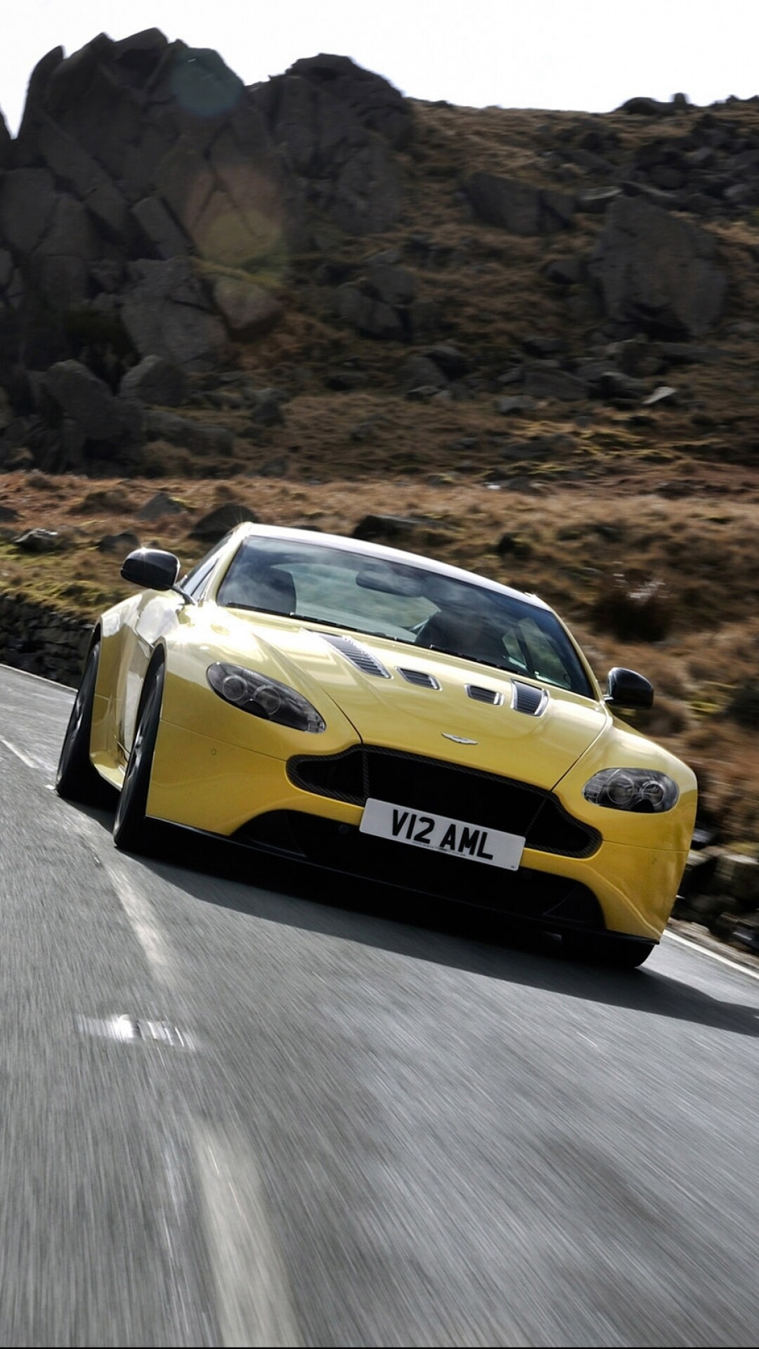 Aston Martin V12 Vantage, V12 AML plate, Rocky mountain road, Yellow sports car Aston Martin V12 Vantage, V12 AML plate, Rocky mountain road, Yellow sports car — 1080×1920 HD wallpaper